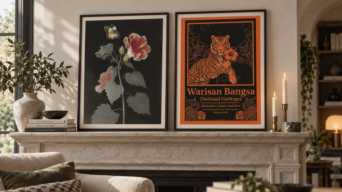 Two framed Malaysia-inspired posters displayed in portrait orientation on a stone mantelpiece in a warm, neutral contemporary interior.