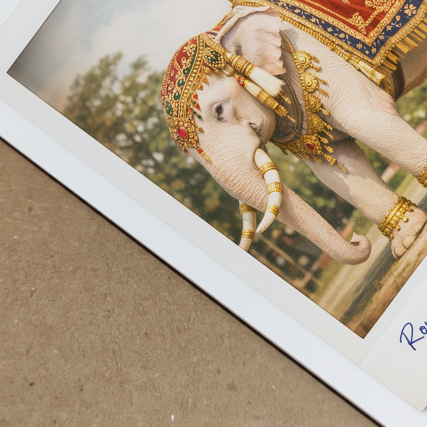 Close-up angled view of the Thailand royal white elephant poster showing print depth and paper texture. The image highlights detailed red and gold royal cloth, gold ornaments and the white elephant’s features. The vintage Polaroid border and handwritten caption are visible, emphasising quality and fine art finish.