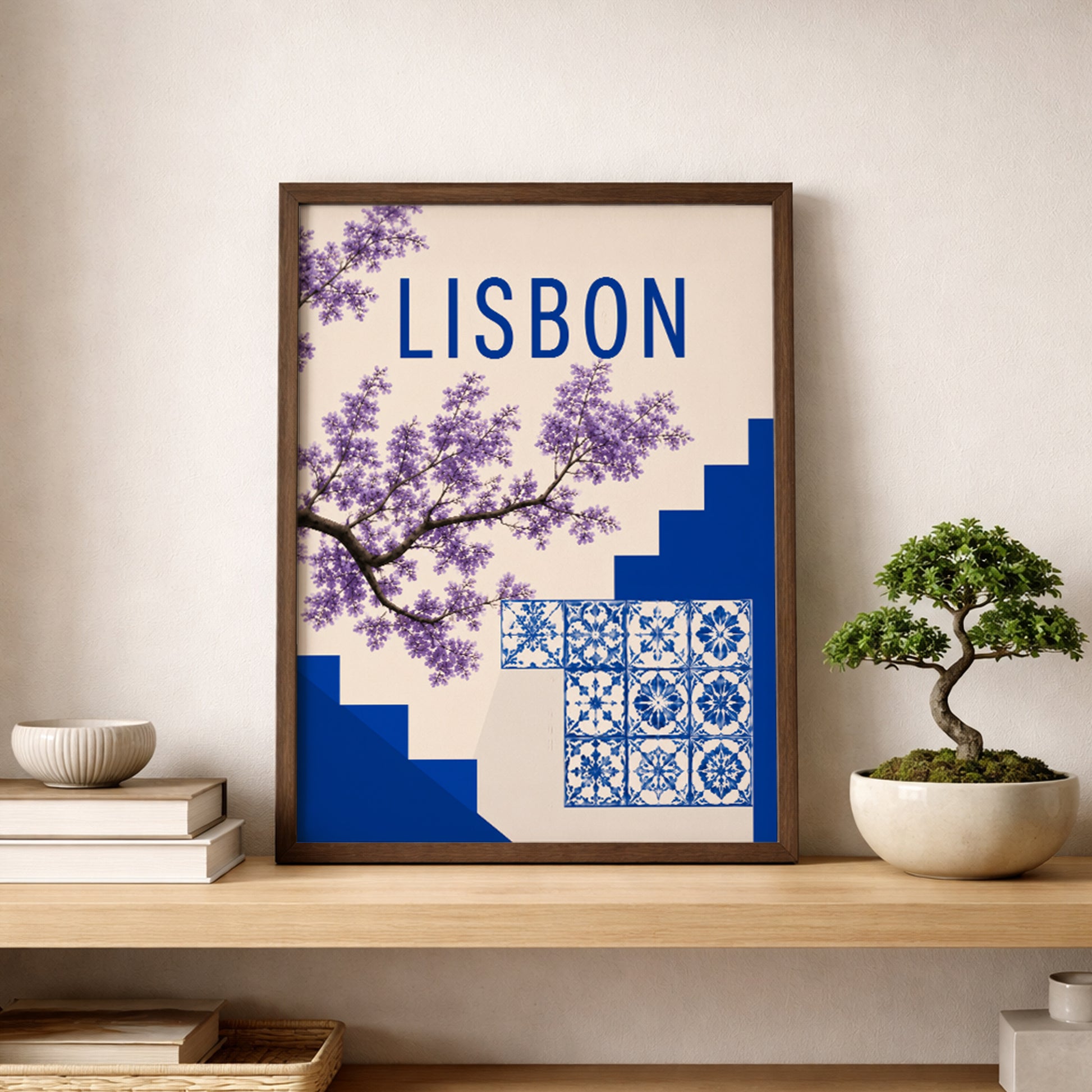 Lisbon poster displayed on a wooden shelf beside a small bonsai plant, with blue azulejo tiles, purple flowers, bold Lisbon text and deep blue steps. A simple Portugal print for shelf styling, hallway decor, bedroom wall art or travel inspired interiors with calm blue and cream tones.