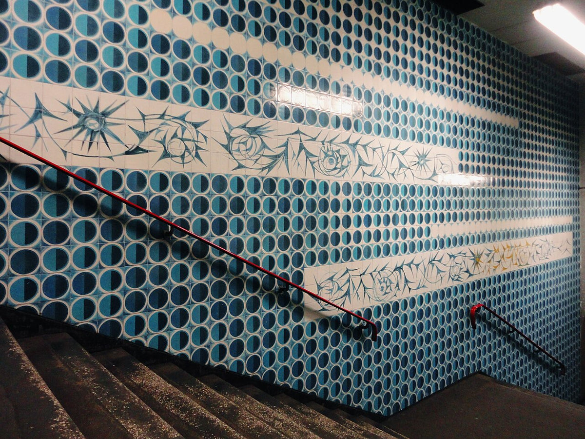 Blue-and-white geometric azulejos by Maria Keil covering the stairwell walls at Intendente Metro station in Lisbon

Manuelvbotelho, CC BY-SA 3.0 <https://creativecommons.org/licenses/by-sa/3.0>, via Wikimedia Commons

https://commons.wikimedia.org/wiki/File:Metro_Lisboa_Anjos_4.jpg