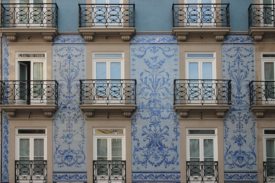 Blue and white Portuguese azulejo ceramic tile wall facade with ornate floral patterns and black wrought iron 
balconies.

John Samuel, CC BY-SA 4.0 <https://creativecommons.org/licenses/by-sa/4.0>, via Wikimedia Commons