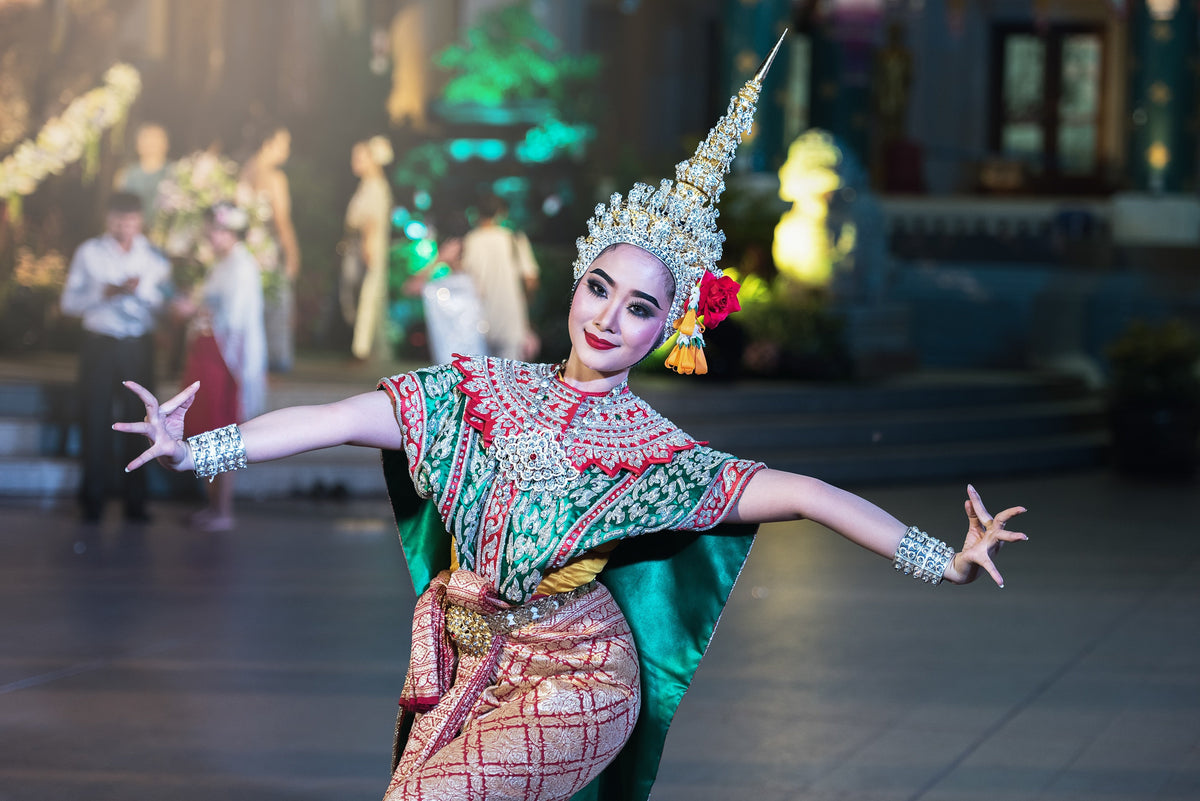 Thai classical dancer in ornate traditional costume and headdress performing a graceful dance pose