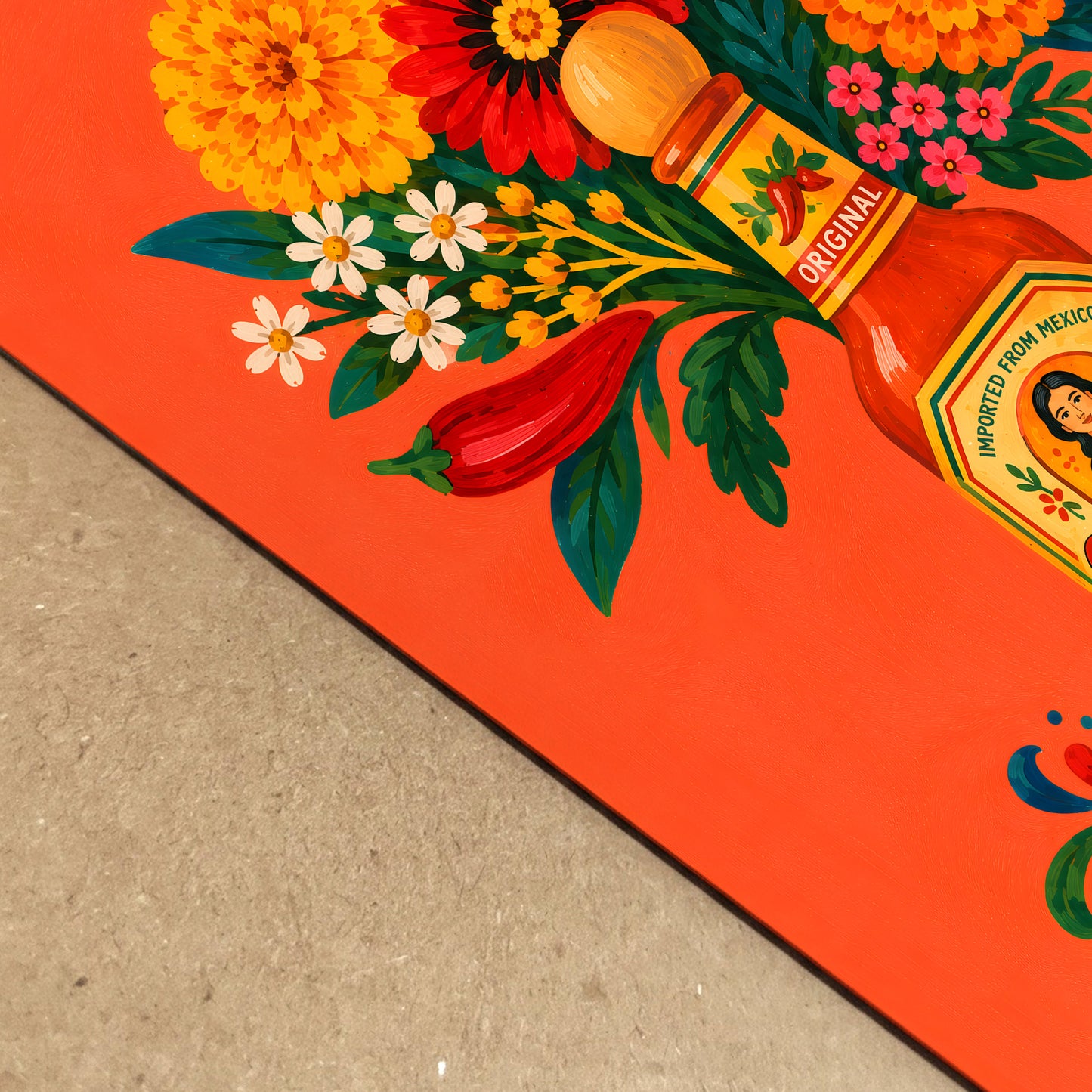 Angled close-up of the Mexican spicy sauce flower print resting on a textured neutral surface, showing crisp orange paper, red chillies, layered flowers, green foliage and detailed illustrated brushwork.