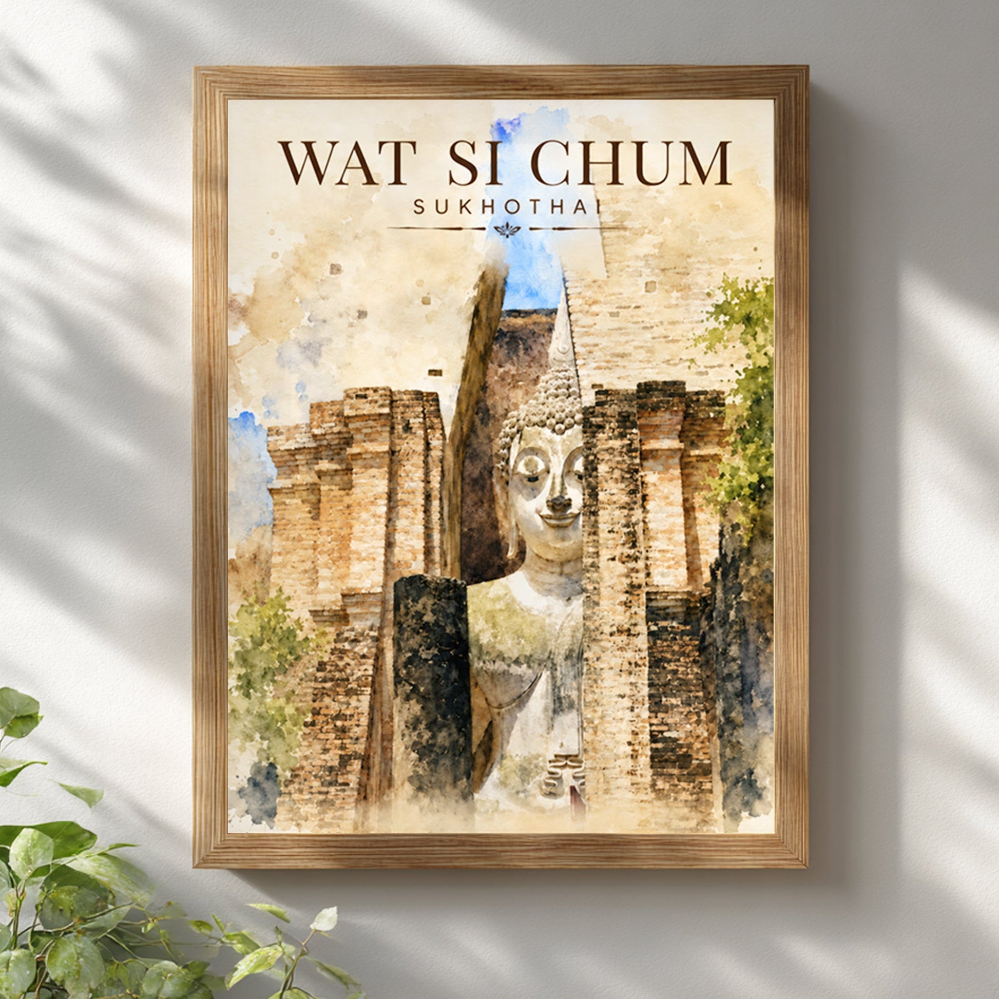 Wat Si Chum Sukhothai art print displayed in a natural wooden frame on a light wall, featuring the monumental Buddha, historic temple brickwork and warm watercolour-style tones.