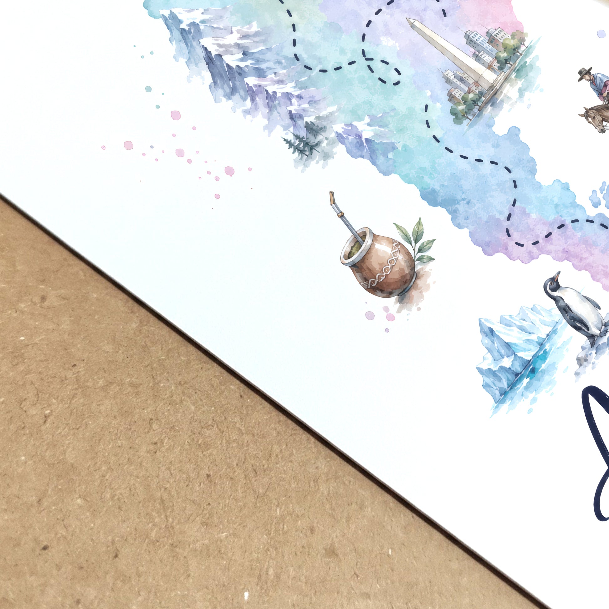 Close-up angled view of the Argentina map print showing the texture and depth of the paper surface. The cropped artwork reveals soft blue, green and lilac watercolour washes, fine map details and small illustrated cultural and wildlife elements. The print lies on a natural wood surface, highlighting its crisp finish and detailed artwork.