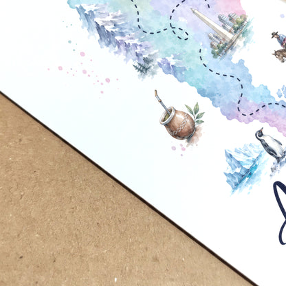 Close-up angled view of the Argentina map print showing the texture and depth of the paper surface. The cropped artwork reveals soft blue, green and lilac watercolour washes, fine map details and small illustrated cultural and wildlife elements. The print lies on a natural wood surface, highlighting its crisp finish and detailed artwork.