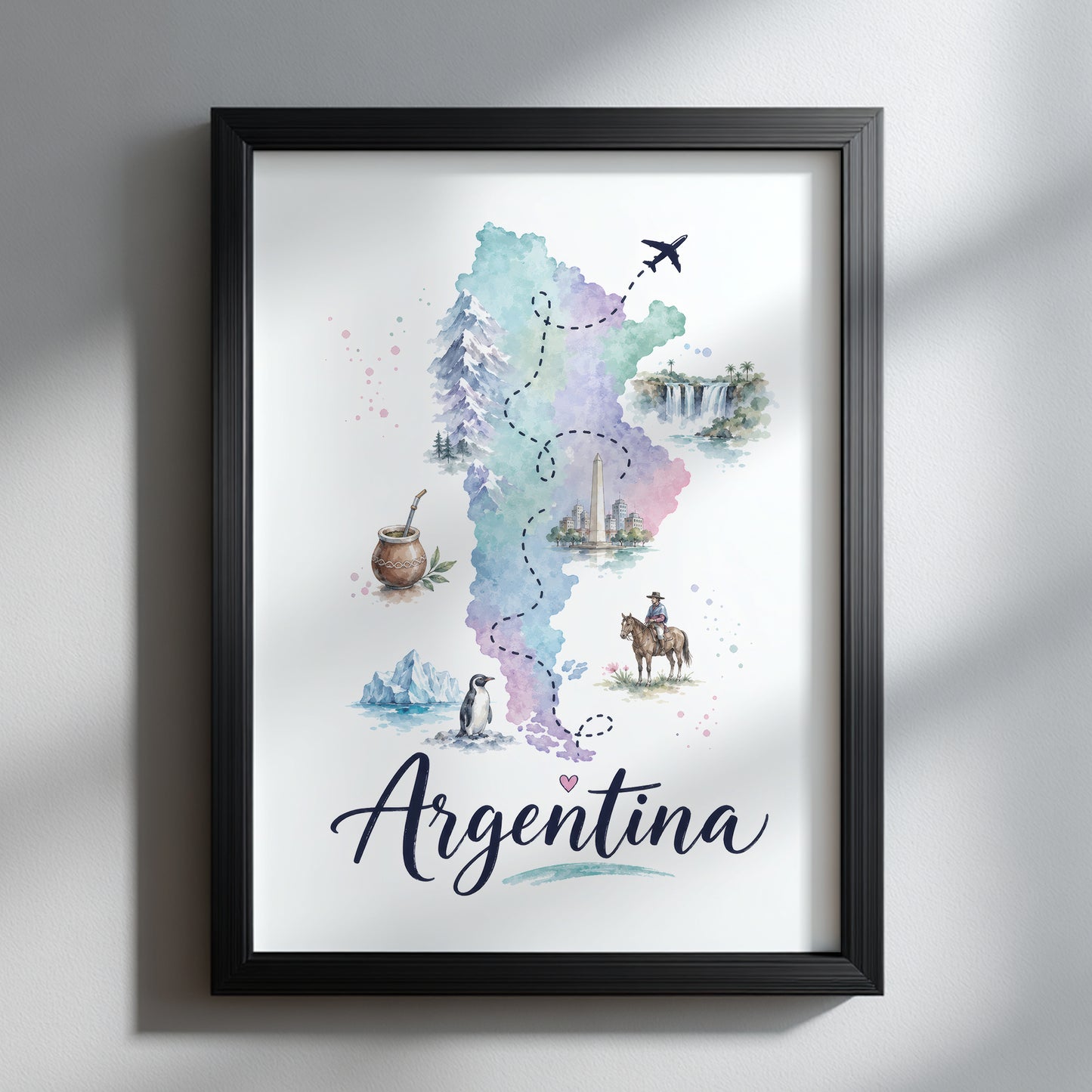 Argentina watercolour map print shown in a slim black frame against a clean light-grey wall. The pale blue, green and purple map includes small wildlife, landscape and cultural illustrations, with flowing Argentina script below. The simple dark frame gives the colourful South America travel artwork a modern, high-contrast finish.