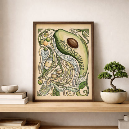 Avocado shake poster displayed on a wooden shelf beside a small bonsai plant and simple decor. The framed print features a sliced avocado, curling vines and hand-drawn recipe details in green and cream shades. The styling shows how the food poster works as kitchen wall art, shelf decor or botanical wall art in a clean and modern home space.
