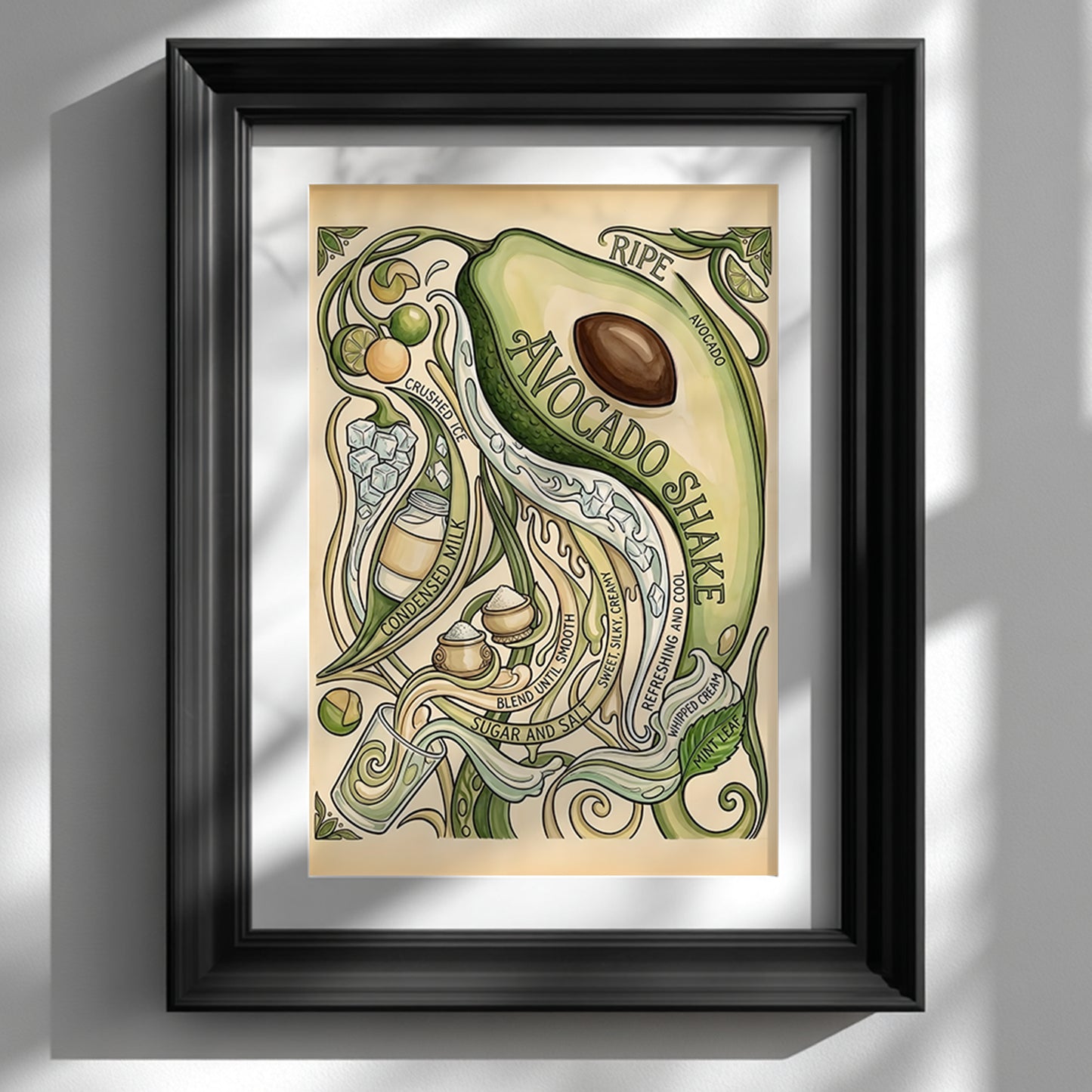 Black framed avocado shake poster displayed on a clean white wall. The vintage-style avocado print features a large sliced avocado, flowing green vines, lime slices, crushed ice and hand-drawn recipe text in soft green and cream tones. Styled as kitchen wall art, the framed food poster has a simple, modern look that suits a bright home interior.