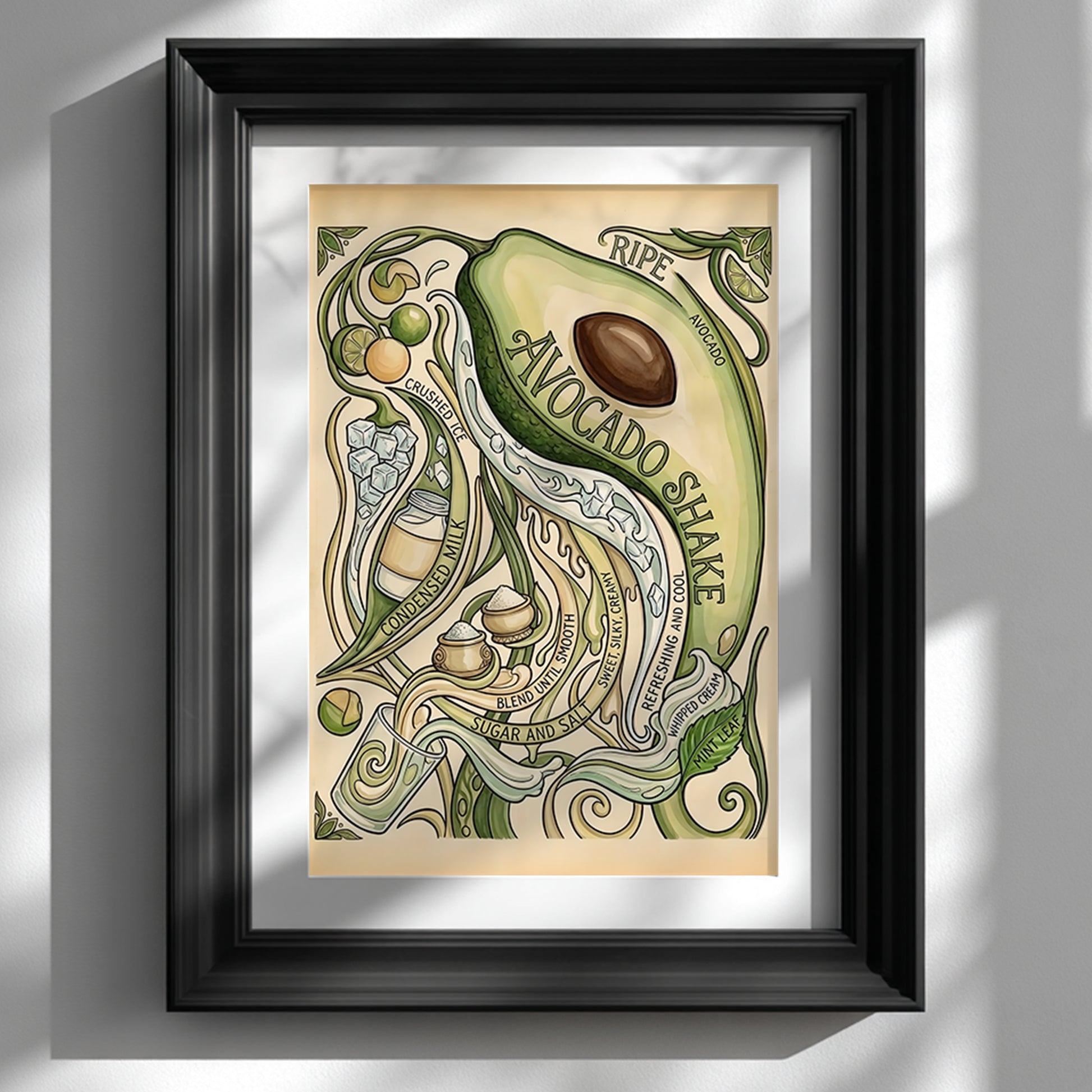 Black framed avocado shake poster displayed on a clean white wall. The vintage-style avocado print features a large sliced avocado, flowing green vines, lime slices, crushed ice and hand-drawn recipe text in soft green and cream tones. Styled as kitchen wall art, the framed food poster has a simple, modern look that suits a bright home interior.