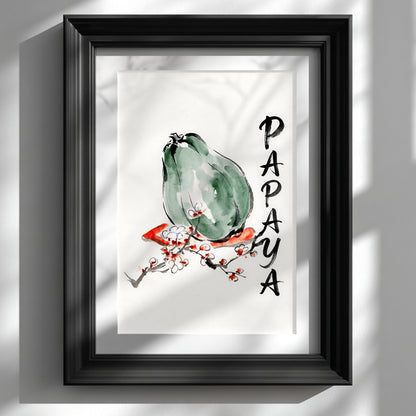 Framed papaya wall art shown in a black frame on a white wall with soft window shadows. The print features a green papaya in loose ink and watercolour style, a red and white blossom branch, and vertical hand painted PAPAYA lettering. Minimal tropical fruit wall art for kitchen decor, dining room styling, modern Asian inspired interiors, and clean botanical gallery walls.