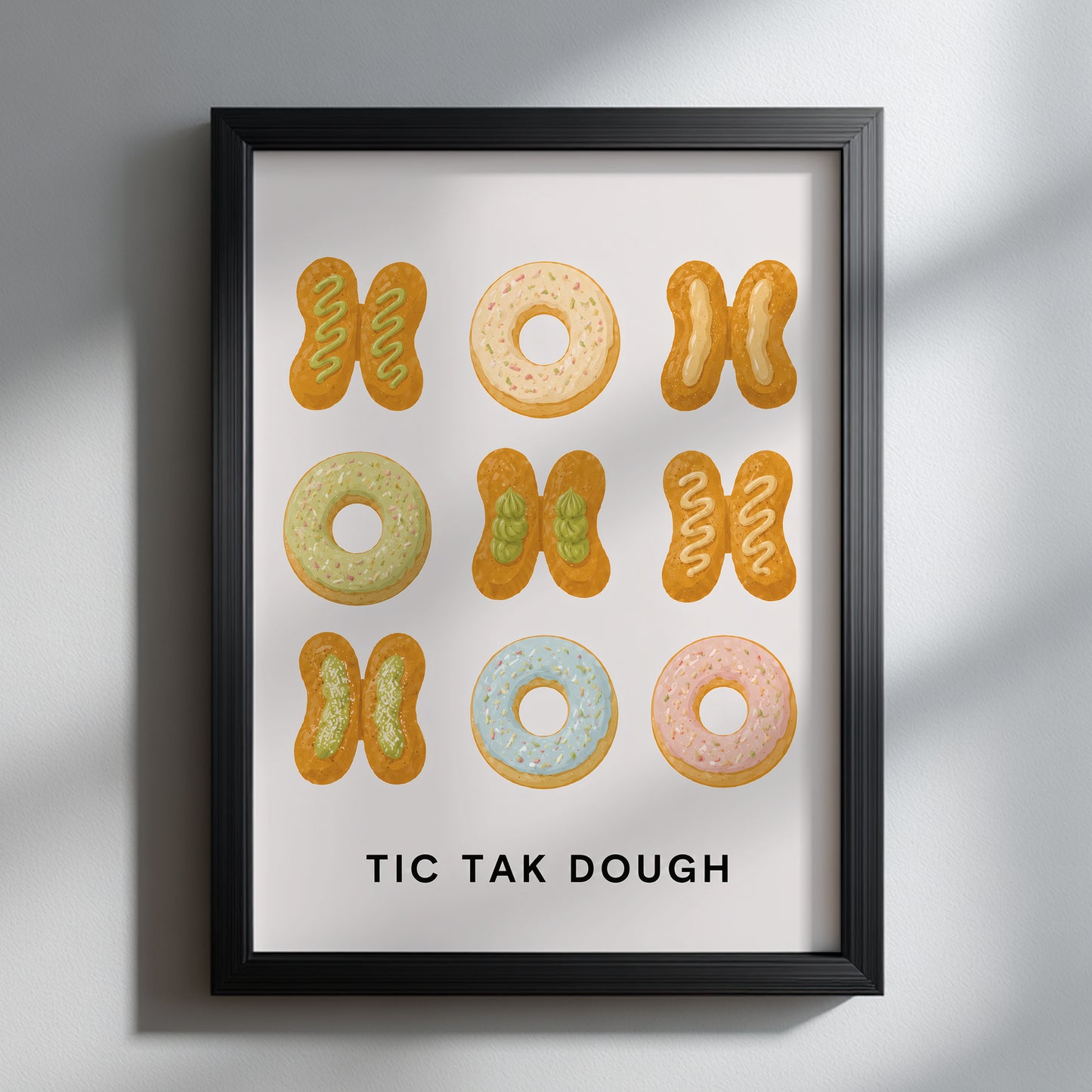 Thai patongo and pastel doughnut kitchen print in a black frame on a light grey wall, with soft diagonal sunlight highlighting the funny TIC TAK DOUGH food artwork.