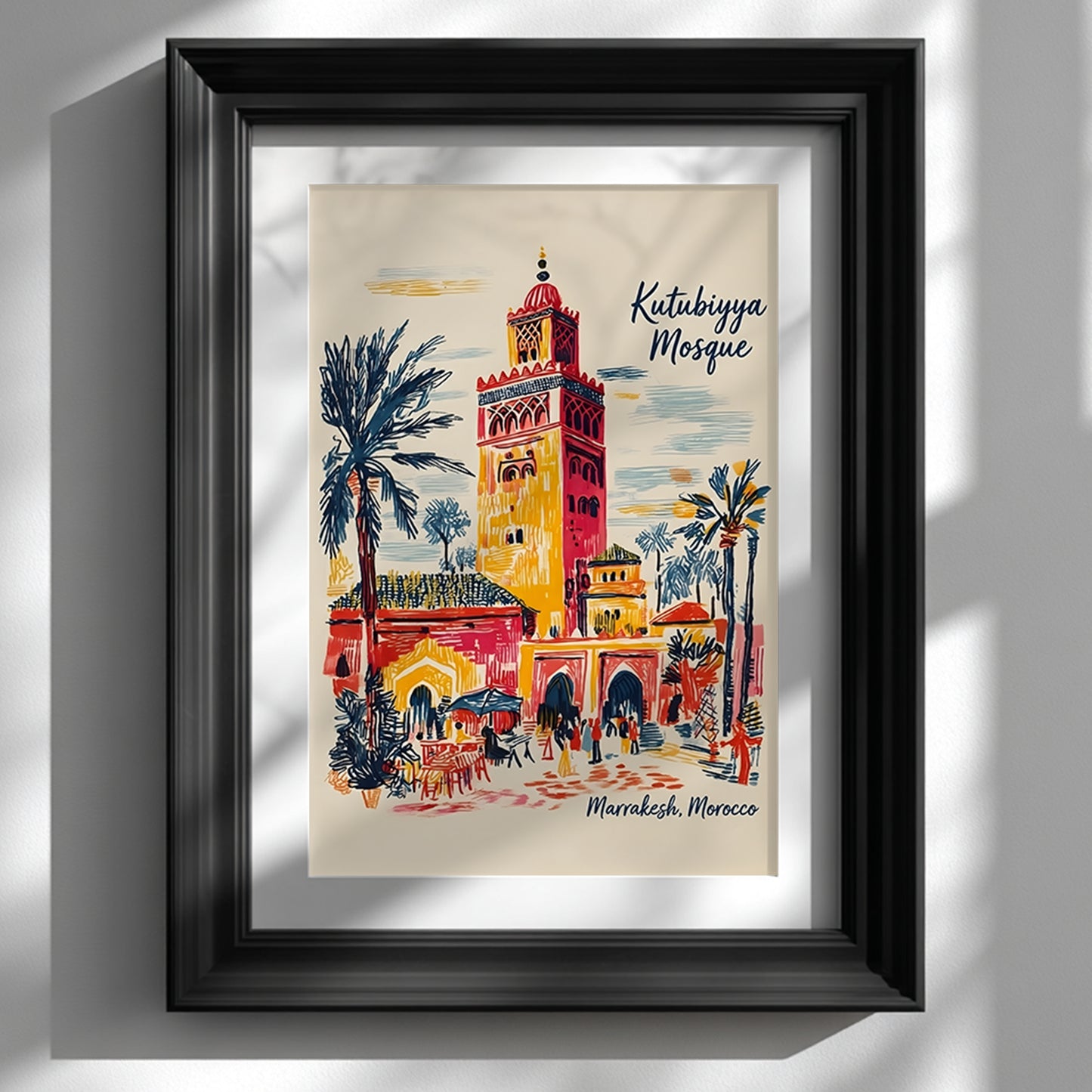 Black framed Kutubiyya Mosque print displayed on a white wall with a wide mount and soft natural shadows. The artwork shows a colourful Marrakech street scene with the mosque tower, palm trees, archways, outdoor seating and small figures in red, yellow, blue and cream tones. A clean mockup for Morocco wall art, Marrakech poster and Moroccan architecture print styling in modern interiors.