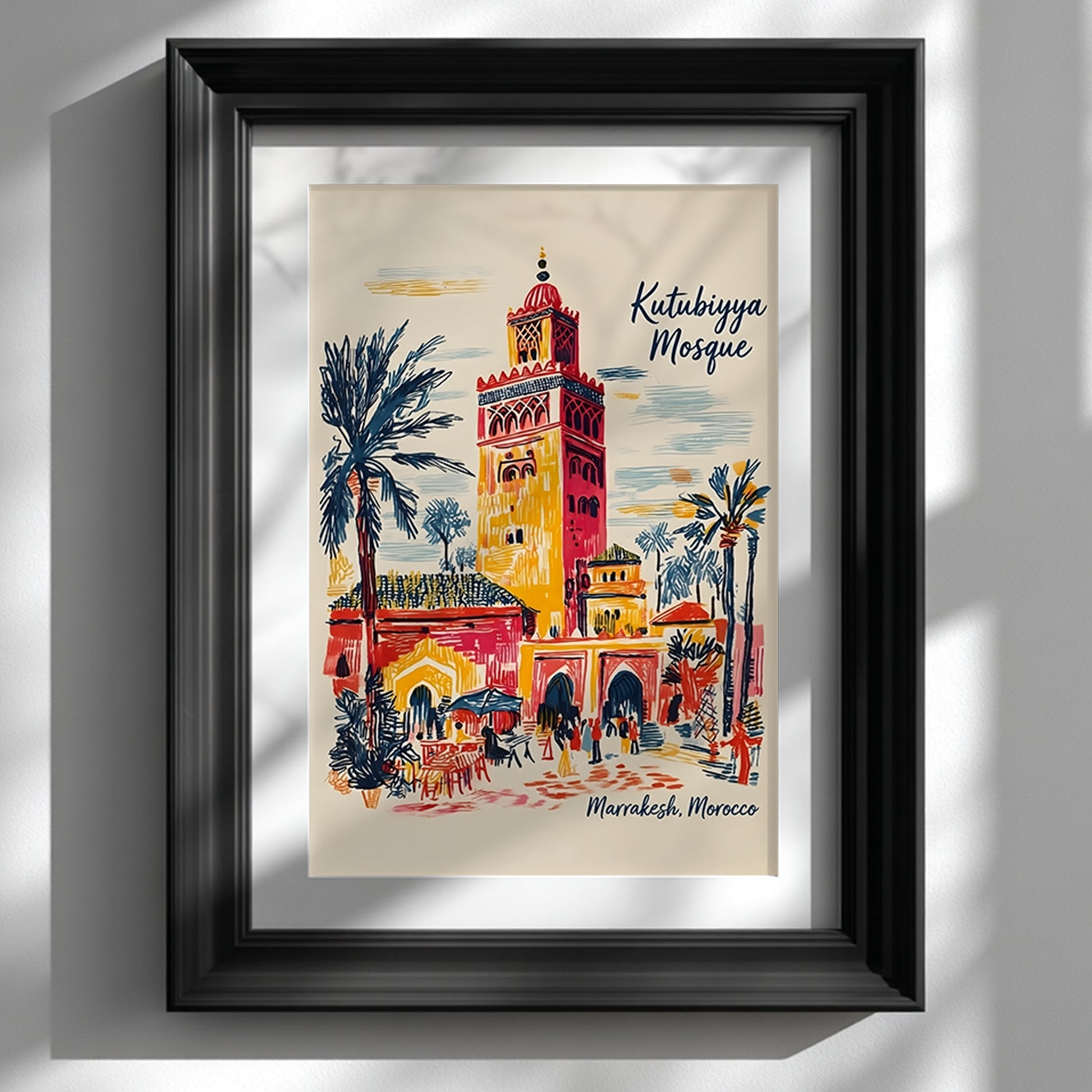 Black framed Kutubiyya Mosque print displayed on a white wall with a wide mount and soft natural shadows. The artwork shows a colourful Marrakech street scene with the mosque tower, palm trees, archways, outdoor seating and small figures in red, yellow, blue and cream tones. A clean mockup for Morocco wall art, Marrakech poster and Moroccan architecture print styling in modern interiors.