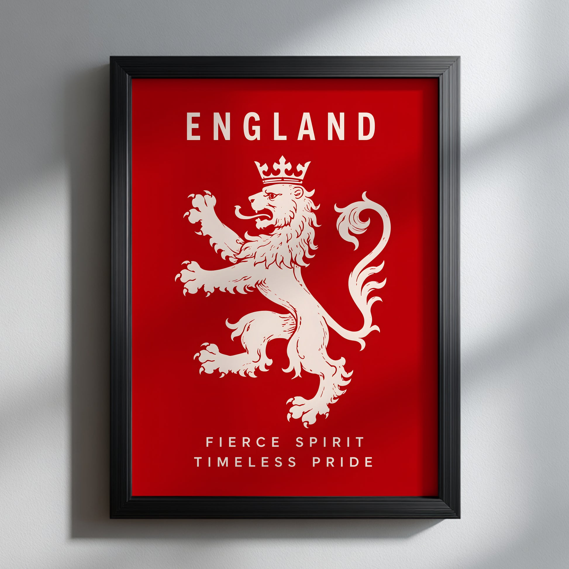 Black framed England lion poster on a light wall, with a cream crowned heraldic lion, ENGLAND lettering and pride slogan against a bold red background.