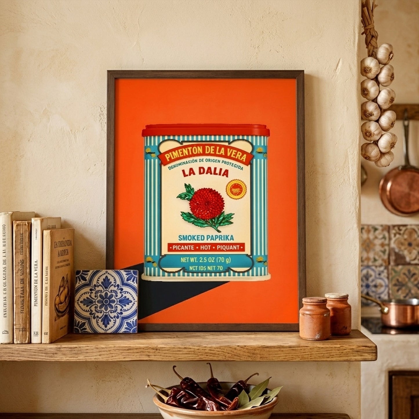 Lifestyle image of the Spanish Smoked Paprika Tin artwork framed and styled on a mantle in a warm interior. The bold orange print stands out against neutral decor, showing the vintage paprika tin design with blue stripes, cream label and red flower. The setting helps place it as Spanish kitchen wall art, retro food artwork or a colourful dining room piece with an easy ready-to-hang look.