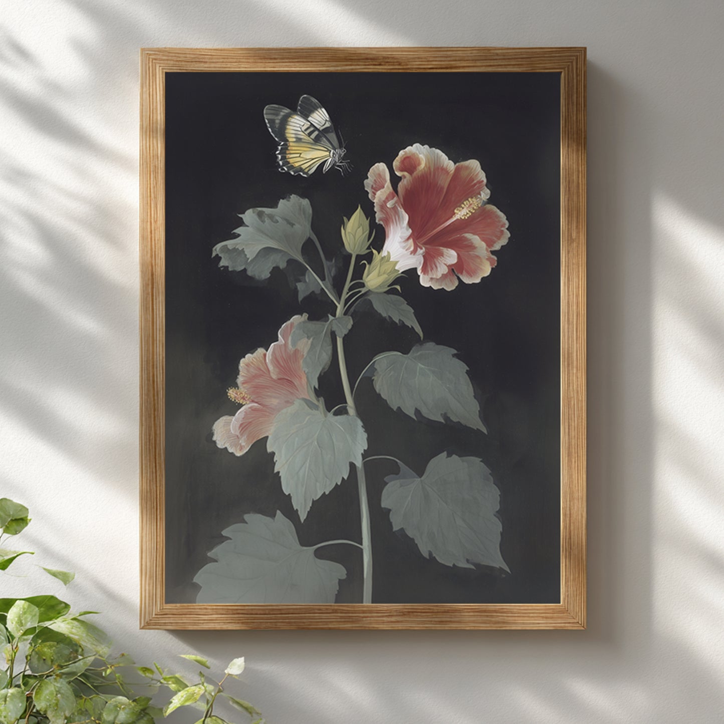 Malaysian hibiscus and Rajah Brooke’s Birdwing butterfly wall art displayed in a light wooden frame on a white wall. The botanical print features red and pink hibiscus flowers with green leaves and a pale yellow butterfly above. Vintage botanical wall art with a clean, minimal presentation suitable for modern interiors.