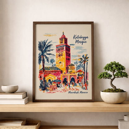 Kutubiyya Mosque print in a simple wood frame resting on a shelf beside a small bonsai-style plant against a soft neutral wall. The Marrakech poster includes the mosque tower, palm trees, arches and street scene details in red, yellow, blue and cream tones. A clean room mockup that shows this Morocco wall art in a calm modern home, ideal for shelf styling in a bedroom, office or hallway.