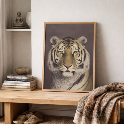 Framed Malayan tiger portrait positioned on a wooden shelf with folded textiles and neutral decor items. The wildlife poster presents a front-facing tiger with defined black stripes and soft fur detail in a vintage photographic style. A strong animal wall decor piece designed for modern or classic interior styling.