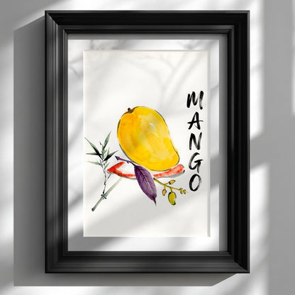 Framed mango wall art print shown on a white wall in a black frame with a white mount. The artwork features a yellow mango painted in loose watercolour with green and purple leaves, a small fruit branch and bold vertical MANGO lettering. Soft window shadows fall across the wall and frame, giving the tropical fruit print a clean, modern look suited to kitchen wall art or bright dining spaces.