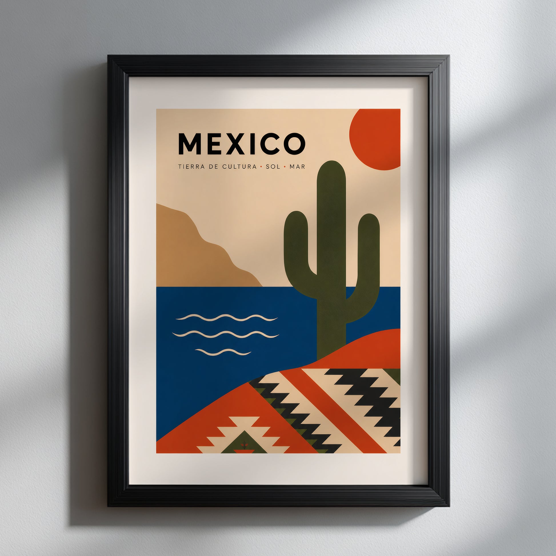 Mexico travel print shown in a slim black frame against a light neutral wall. The bold cactus, red sun, blue sea and geometric pattern stand out clearly, demonstrating how this modern Mexican poster adds colour and a clean travel-inspired focal point to contemporary living rooms, bedrooms or offices.