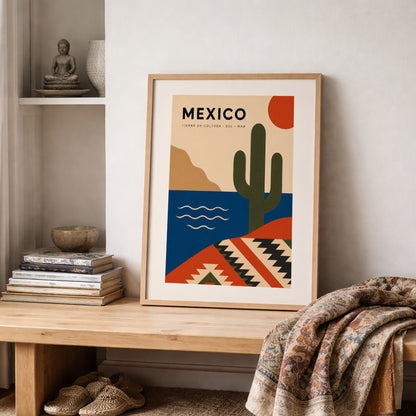 Mexico travel poster in a natural wood frame styled on a shelf with books, neutral decor and a soft patterned throw. The colourful cactus, sun, sea and geometric Mexican design adds a bold but balanced focal point, ideal for cosy living rooms, bedrooms and travel-themed home interiors.
