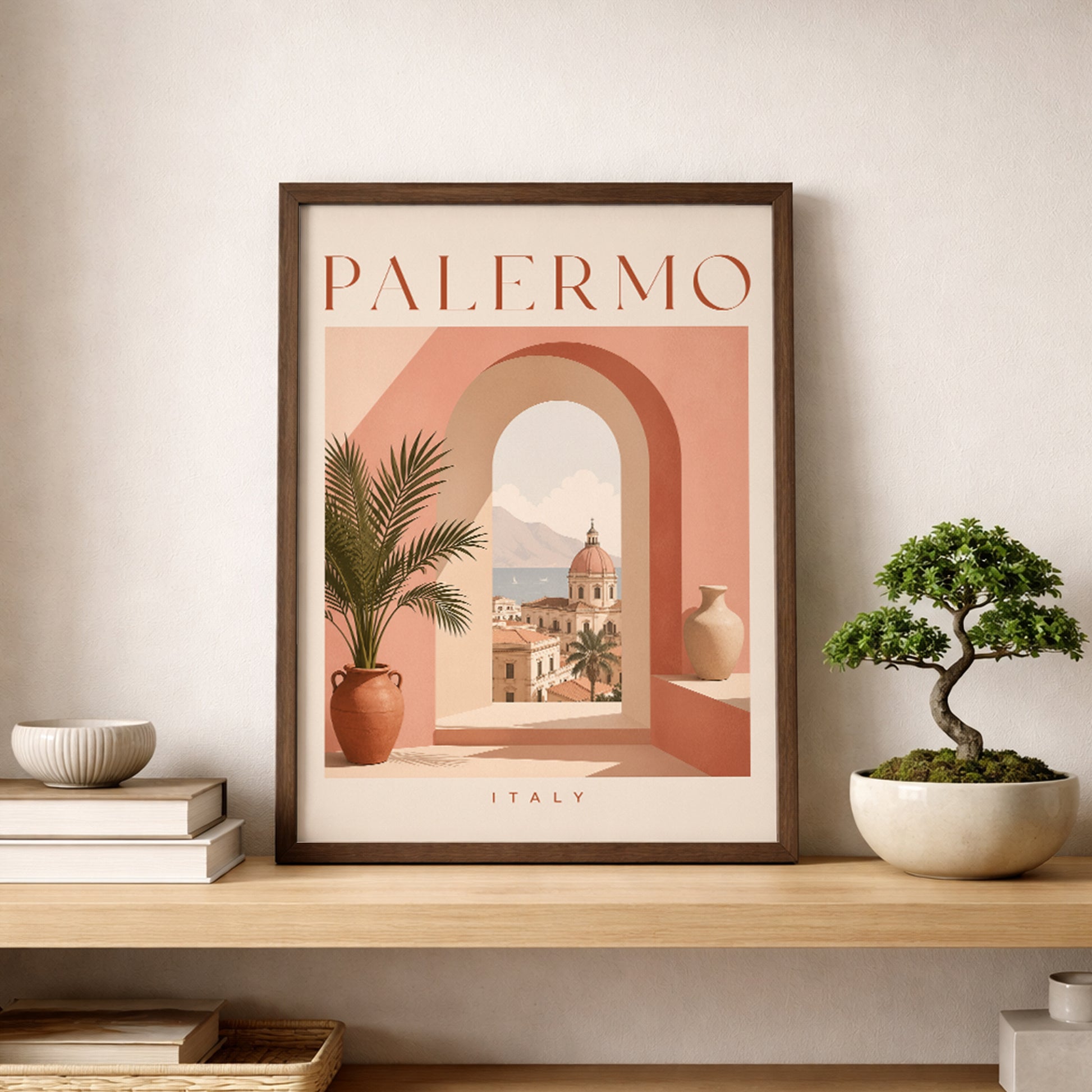 Palermo travel print in a slim dark frame, styled on a pale wooden shelf beside a small bonsai tree and neutral ceramic bowl. The poster combines peach, terracotta and cream tones with an arched Sicilian cityscape and potted palm. A clean modern display for Italian wall art, Mediterranean decor and travel poster interiors.