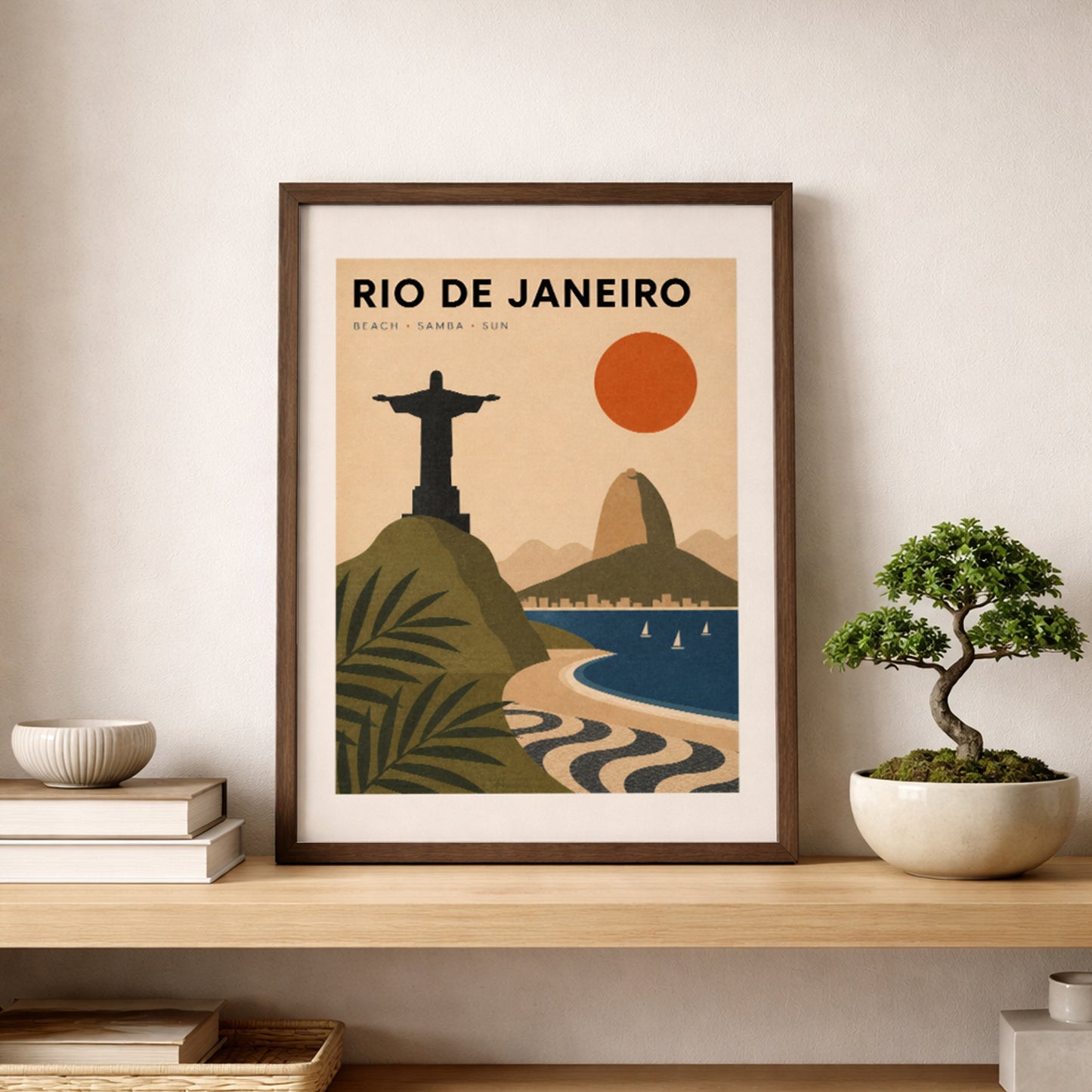 Rio de Janeiro travel poster in a black frame, displayed on a wooden shelf beside a small bonsai plant and neutral home accessories. The retro Brazil wall art features Christ the Redeemer, Sugarloaf Mountain, Copacabana Beach, tropical greenery and bold orange, olive and blue tones.