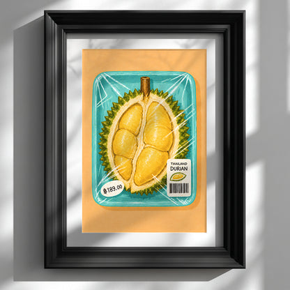 Thai durian market art print showing packaged yellow durian in a turquoise tray, displayed in a deep black frame with a white mount on a sunlit wall.