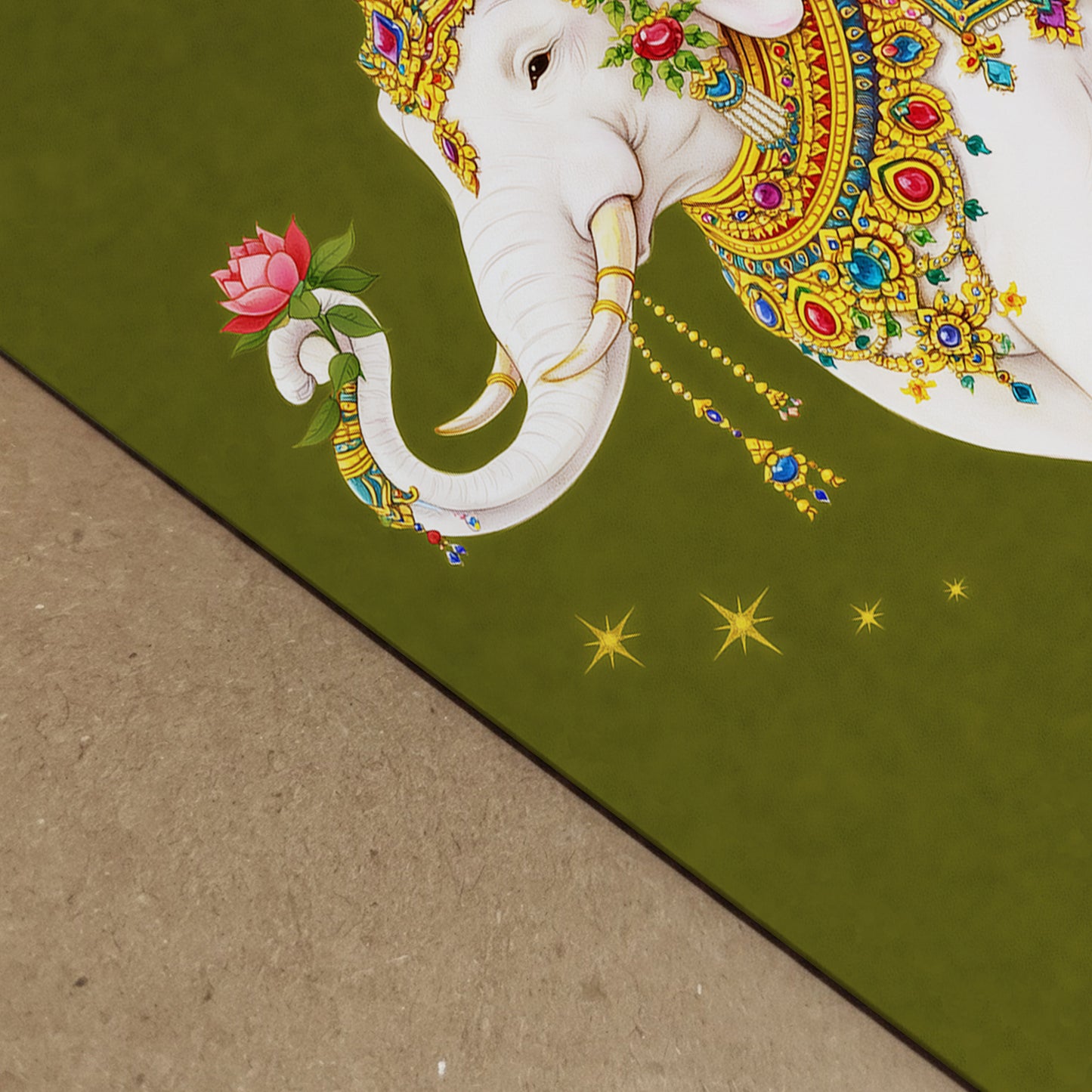Close-up photograph of the Thai royal white elephant print showing paper texture and fine detail. The white elephant’s decorated trunk holds a pink lotus flower, surrounded by small golden star motifs on an olive green background. The image highlights print quality, colour vibrancy and the intricate gold Thai ceremonial ornamentation.