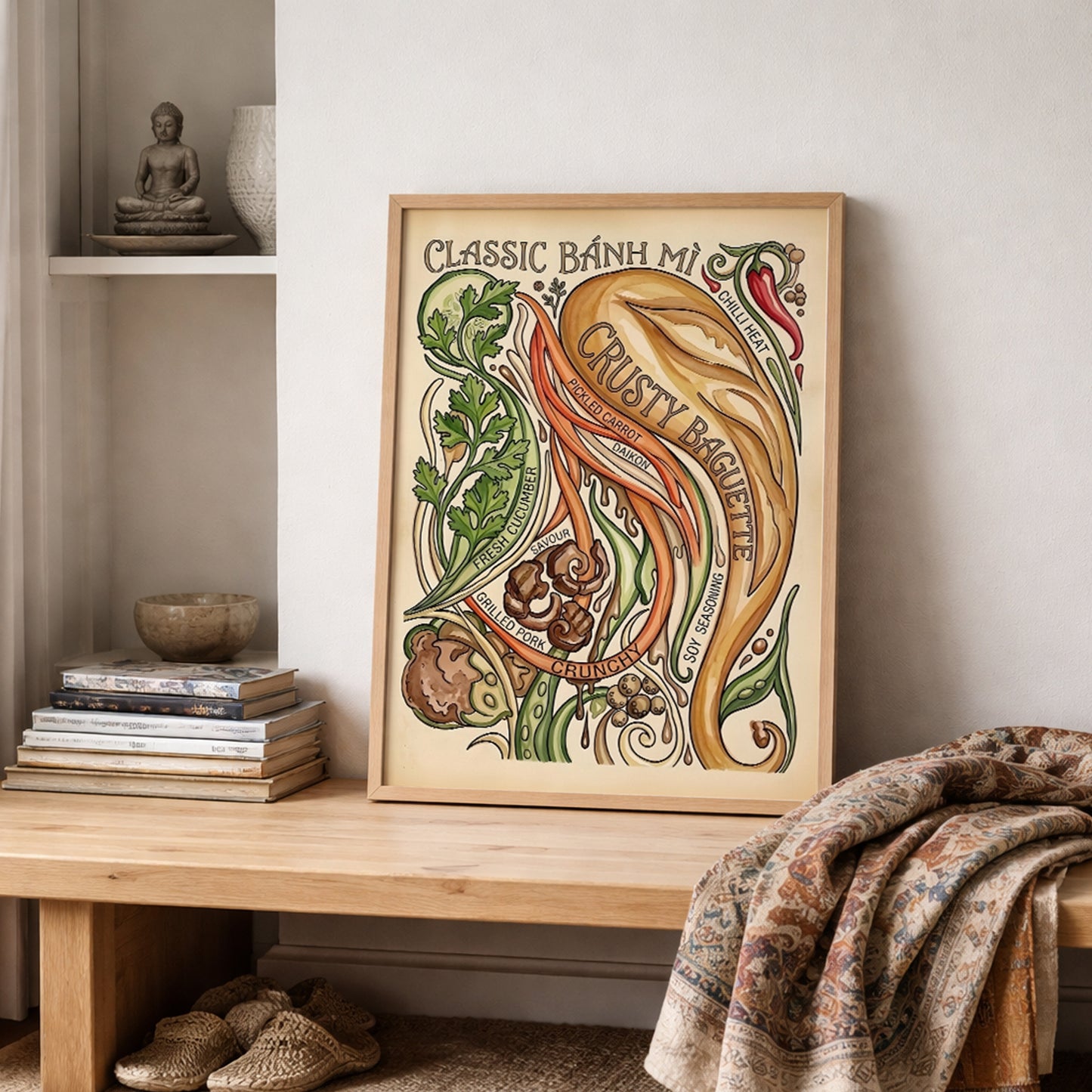 Vietnamese food poster displayed on a wooden shelf with books, soft fabrics and simple home styling. The Banh Mi Poster features vintage recipe art with baguette, chilli, herbs, pickled carrot, daikon and grilled pork, making it a strong choice for cosy kitchen décor, dining rooms and food-themed gallery walls.