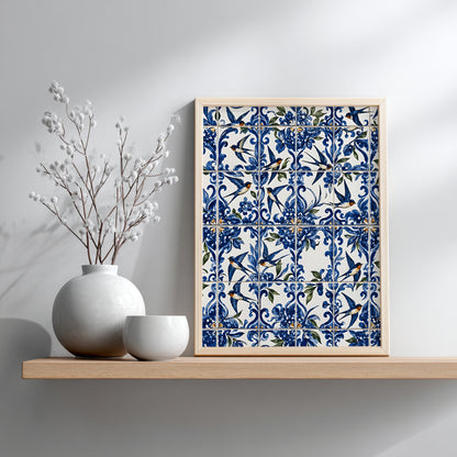 Portuguese swallow azulejo print in a small wooden frame resting on a shelf against a grey wall, beside simple white ceramic vases and decorative branches.