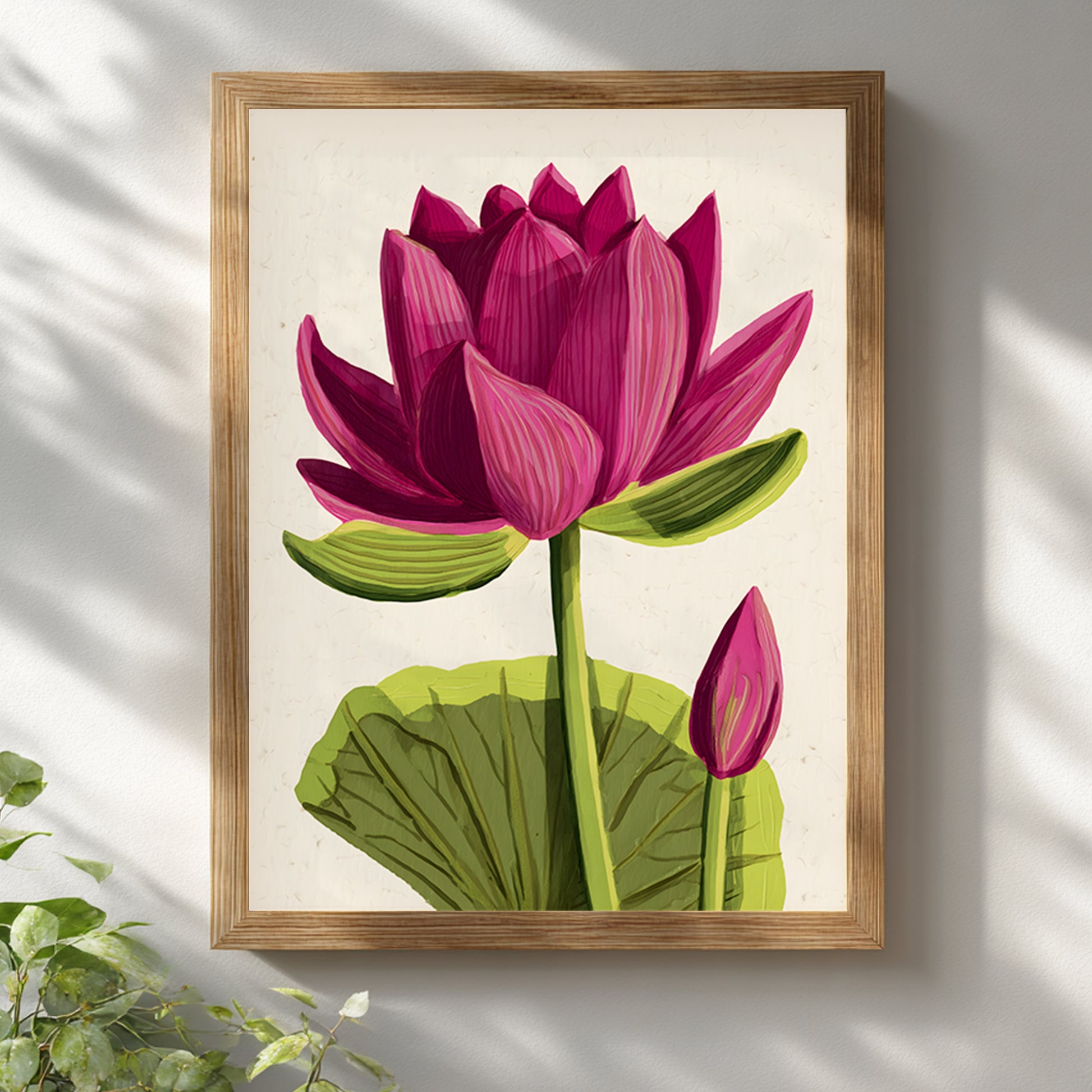 Framed pink lotus flower wall art in a light wooden frame displayed on a white wall. The artwork features a large pink lotus bloom with layered petals, green stem, wide leaf and smaller bud on a clean beige background. Botanical lotus poster styled for Scandinavian, minimalist and zen home interiors.